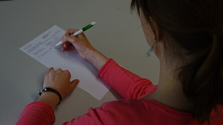 Eine junge Frau beim Ausfüllen eines Prüfungsbogens