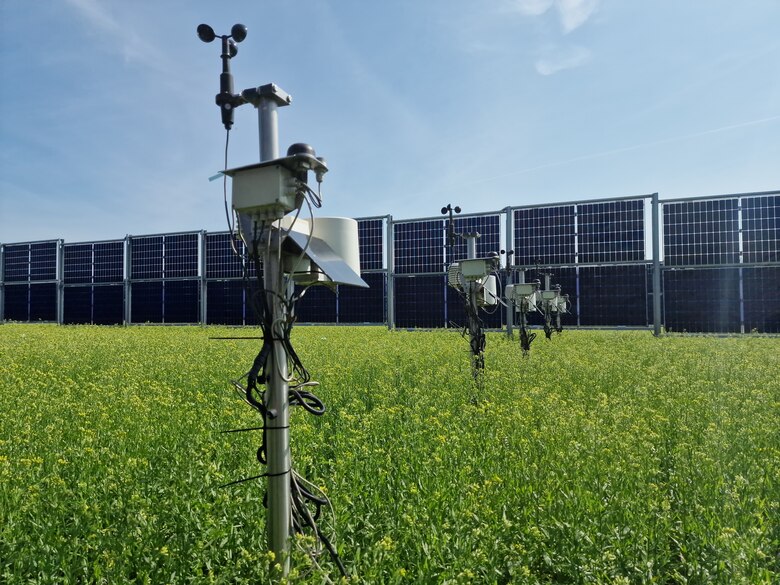 Agri-PV Anlage mit Wetterstation im Vordergrund auf dem Feld