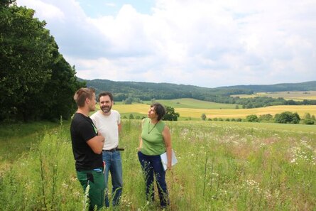 Beratung im Naturschutz, drei Menschen auf Feld