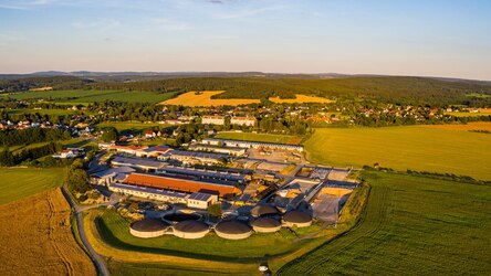 Luftbild Landwirtschaftsbetrieb mit Stallgebäuden und Feldern im Vordergrund, Himmel im Hintergrund