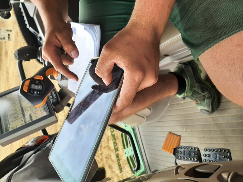 Landwirt mit Tablett im Traktor bei der Arbeit
